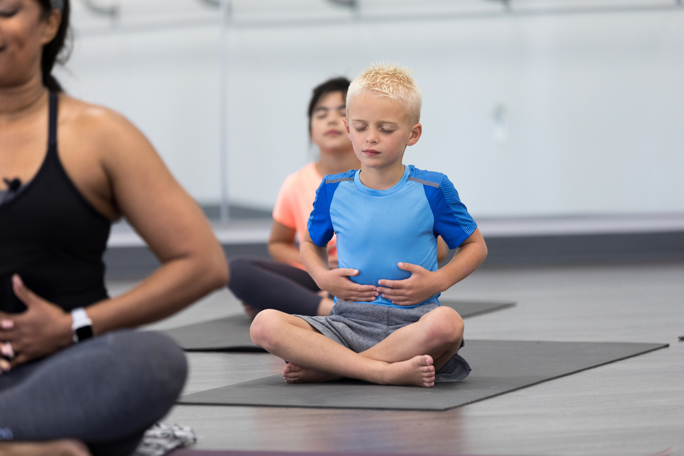 Calm little boy practices breathing exercises